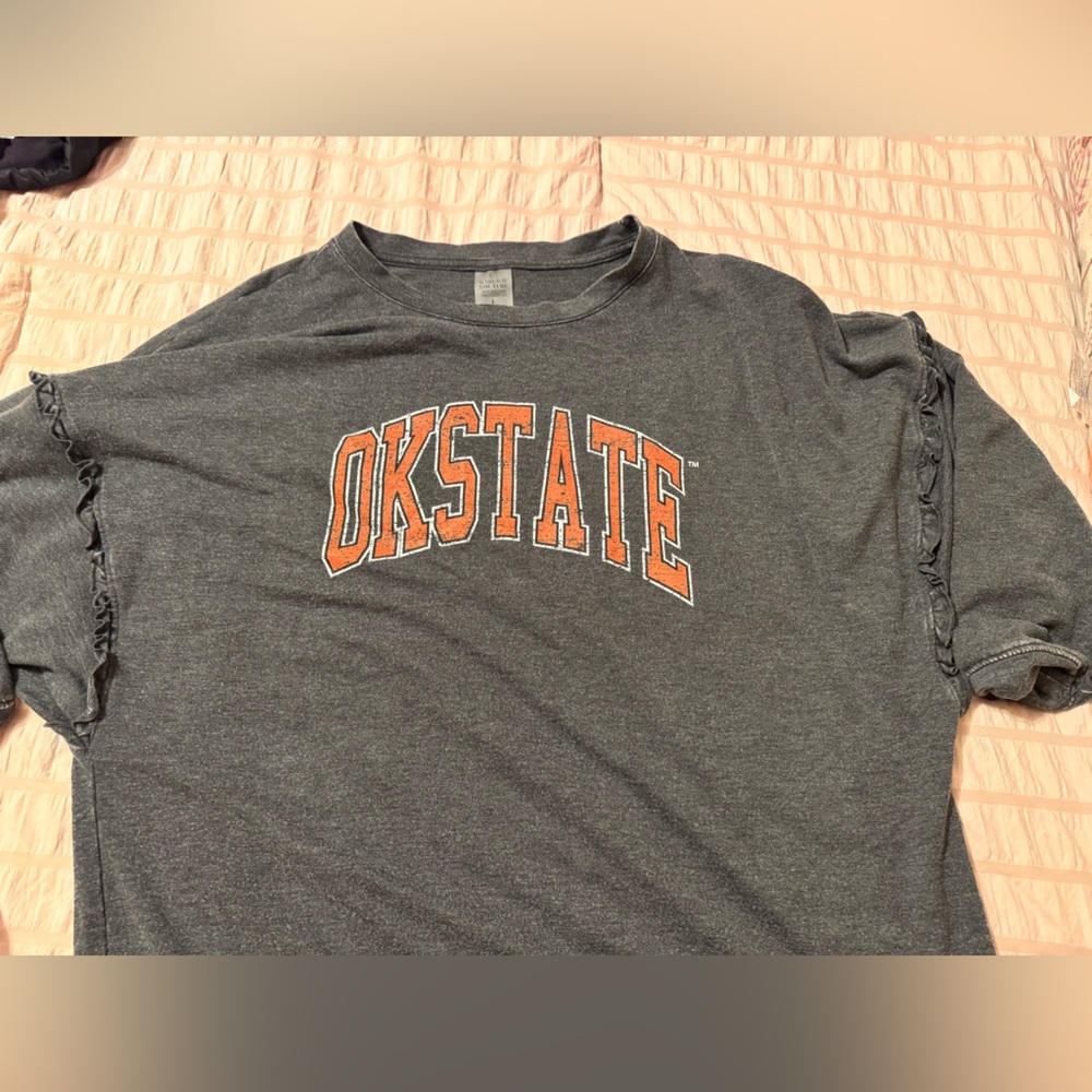 Gray OKSTATE women’s Shirt with cute ruffle detail.